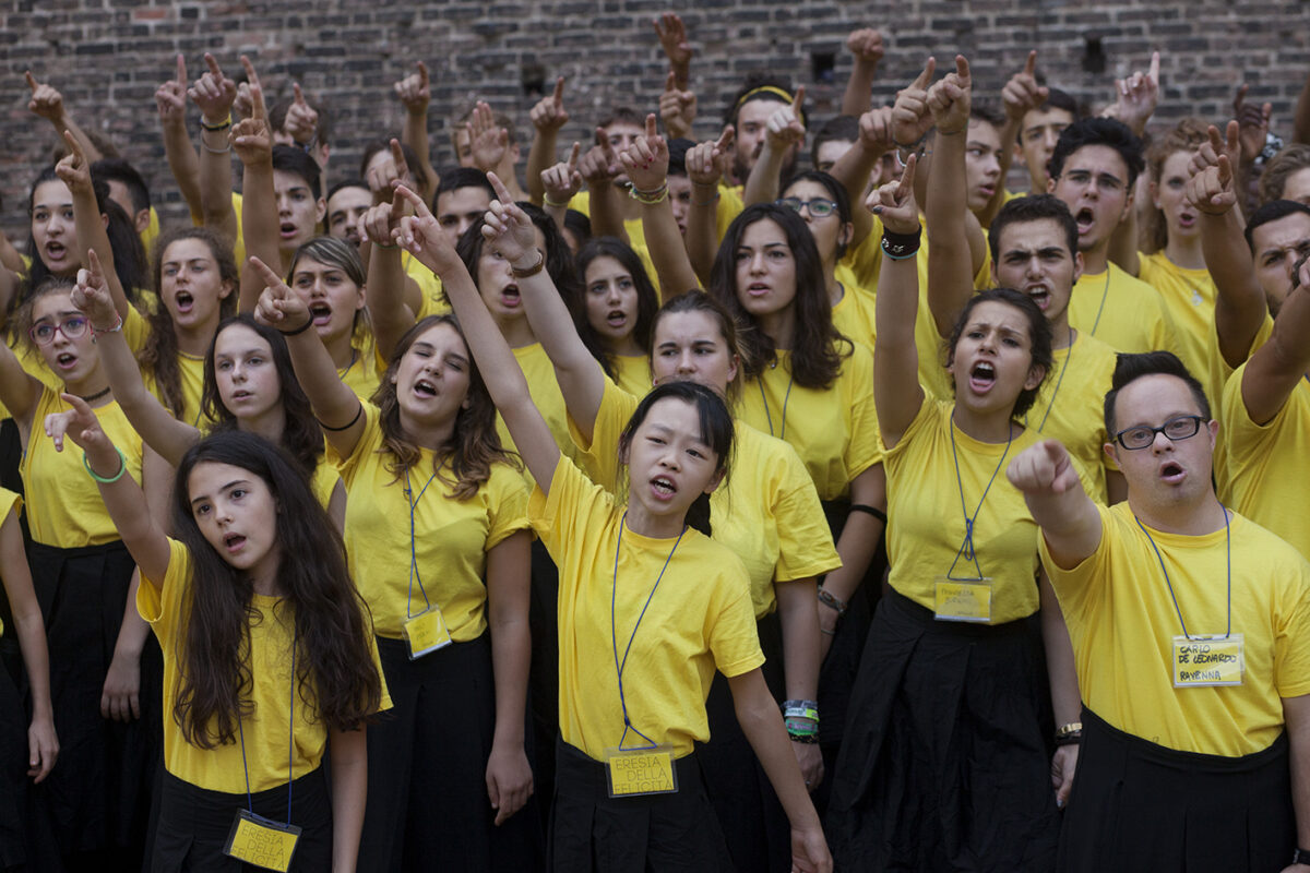 Adolescenti in maglietta gialla intonano, con i pugni al cielo, i versi del poeta russo Vladimir Majakovskij nel fossato del Castello Sforzesco di Milano