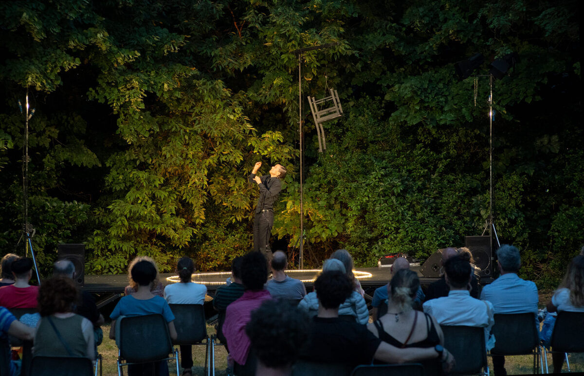 Performer su un piccolo palco immerso nel verde del parco del Paolo Pini, durante lo spettacolo Abracadabra, Festival Da Vicino Nessuno è normale 2020