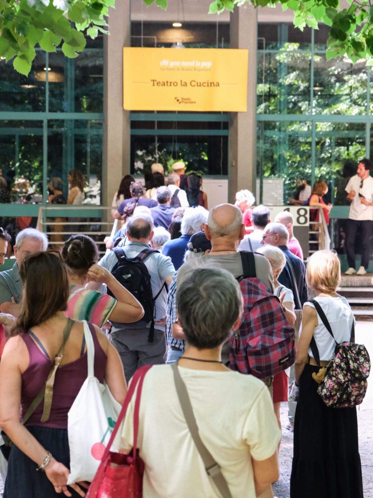 Un gruppo di persone attende in fila di entrare a teatro durante la festa di radio popolare