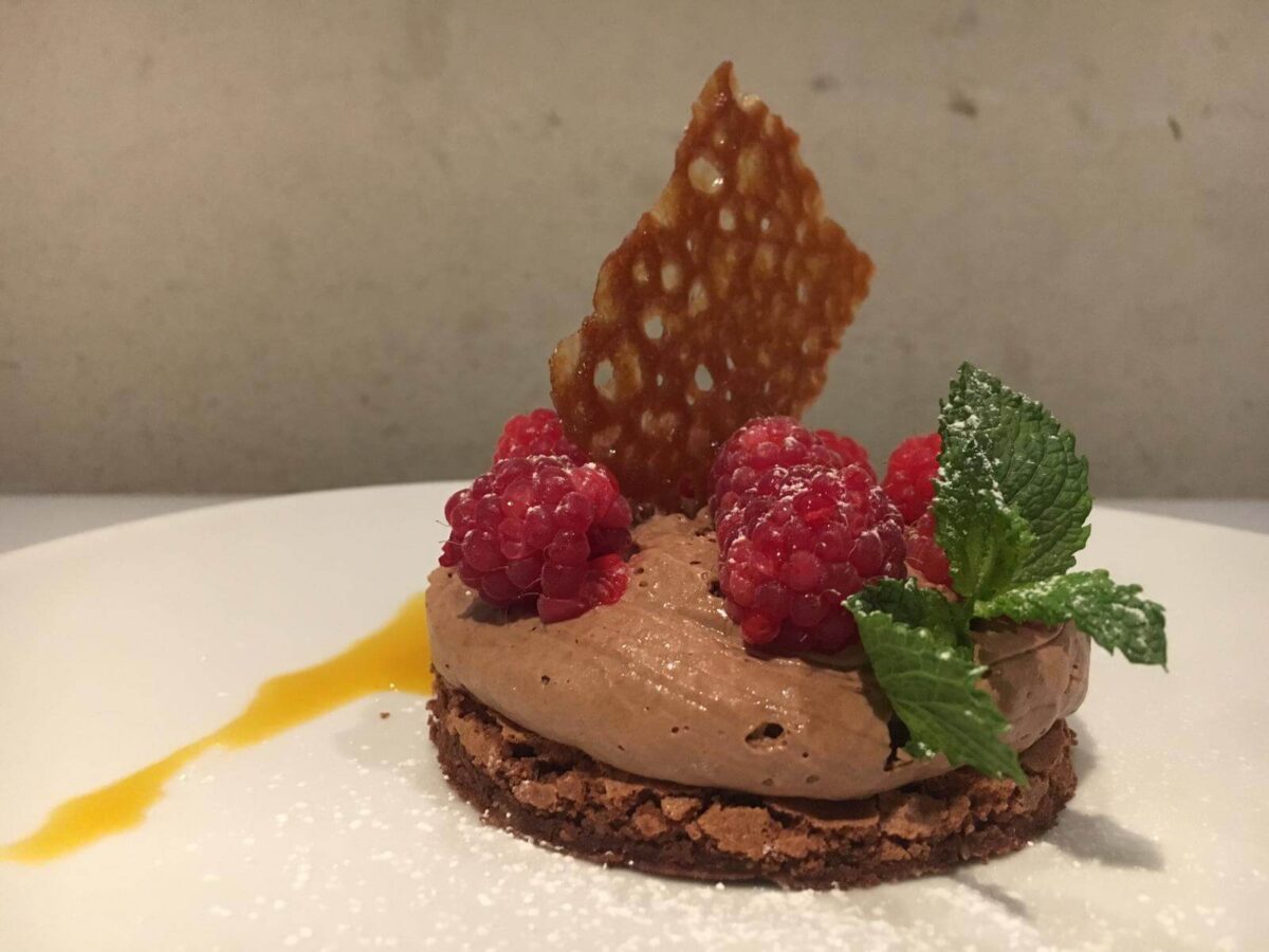 Dessert al cioccolato con lamponi freschi e cialda croccante, preparato al ristorante Jodok.