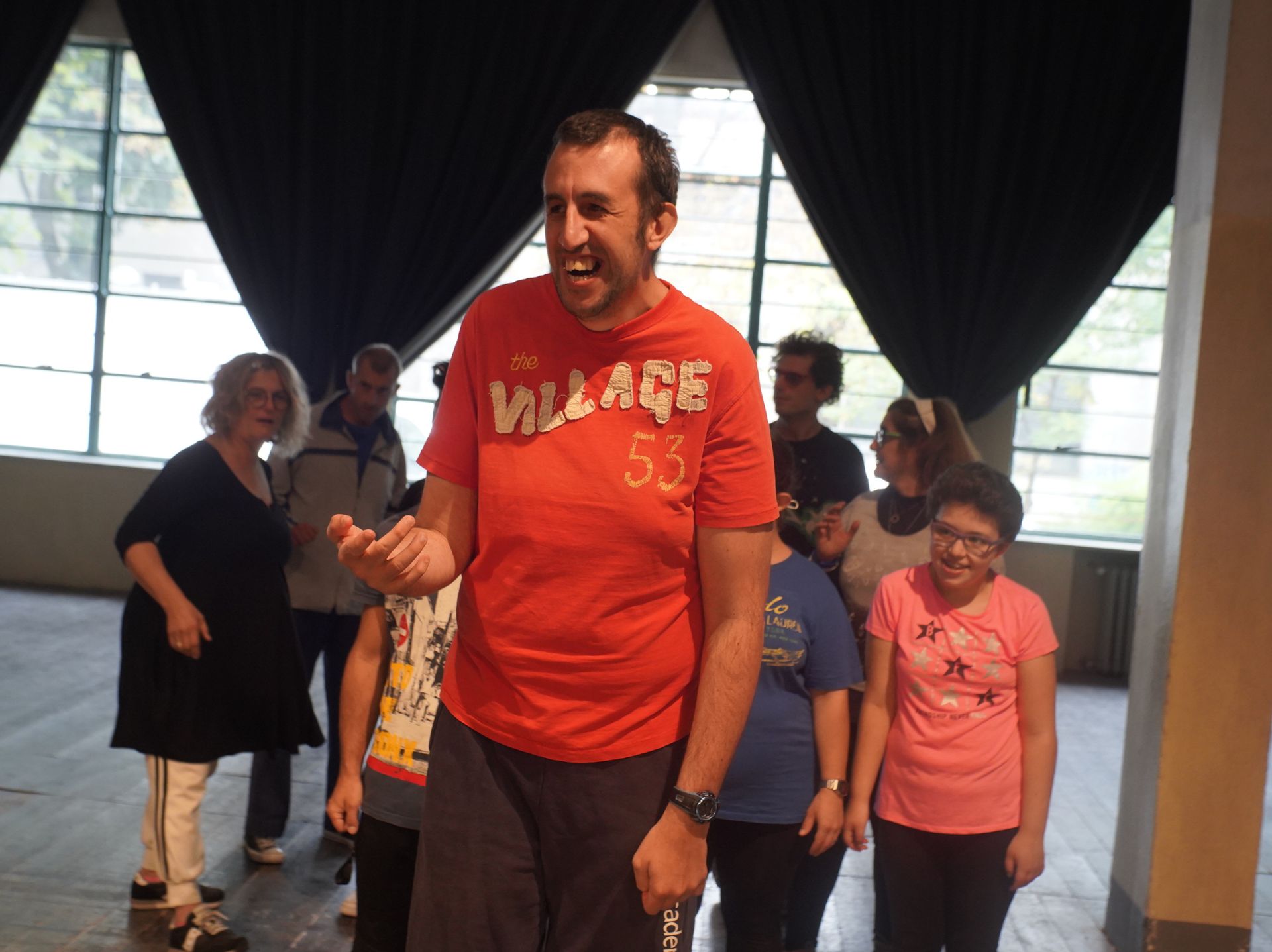 In primo piano un ragazzo in maglia rossa ride compiaciuto, mentre dietro di lui i compagni cercano di capirne, perplessi, le ragioni