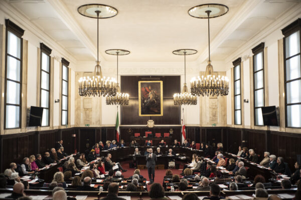 Al centro dell'aula del consiglio comunale di palazzo marino, l'attore che interpreta primo levi, tutto intorno sugli scranni il pubblico, in una disposizione semicircolare