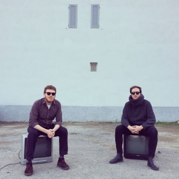 Giovanni Ortoleva ed Edoardo Sorgentr seduti su due vecchie tv su uno sfondo bianco