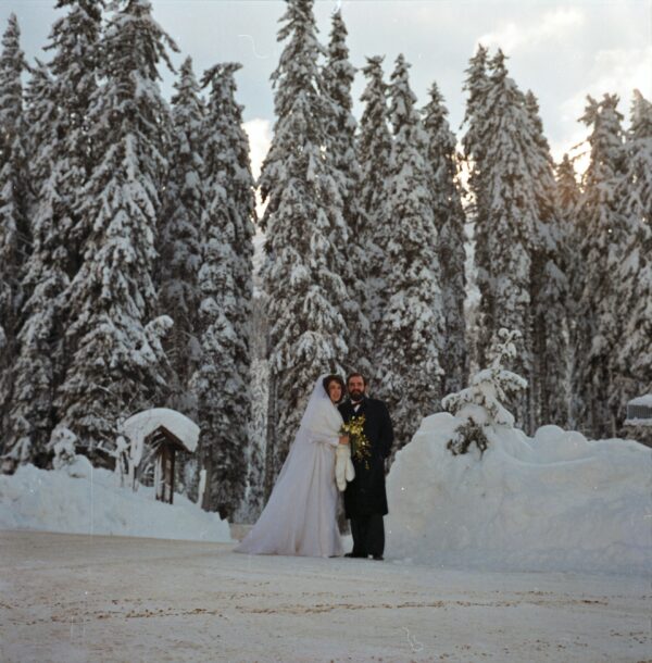 Una coppia in abito da sposi in un bosco innevato, in una cornice fiabesca