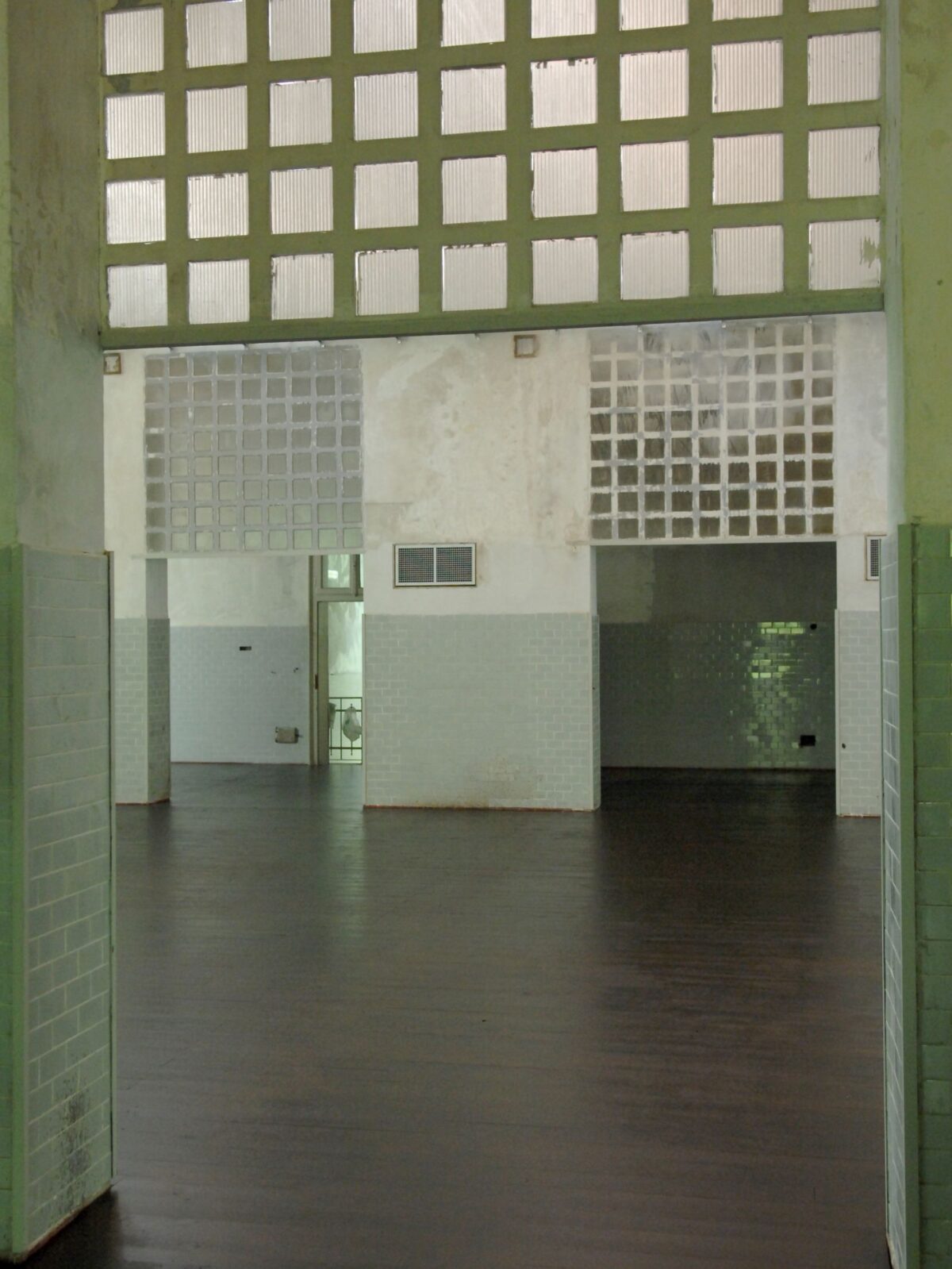 corridoio del teatrolacucina, ex mensa dell'ospedale psichiatrico paolo pini, con piastrelle verdi e architettura industriale, con apertura sulla sala/palcoscenico